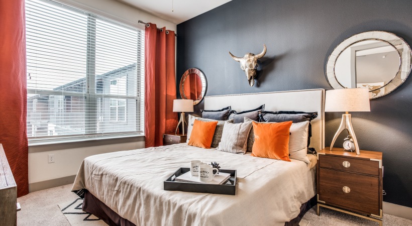 a bedroom with orange accents and black walls at The Teak at  Branch