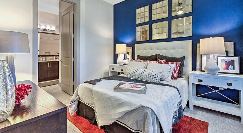 a bedroom with blue walls and red accents at The Teak at  Branch