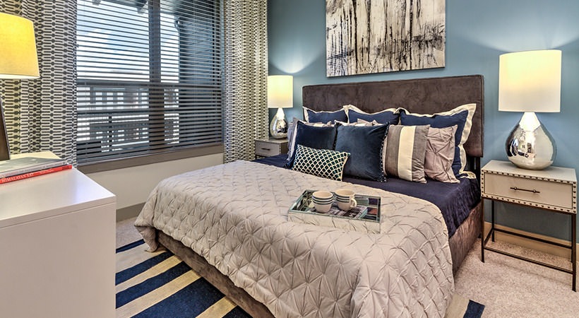a bedroom with blue walls and a bed with a blue and white striped comforter at The Teak at  Branch