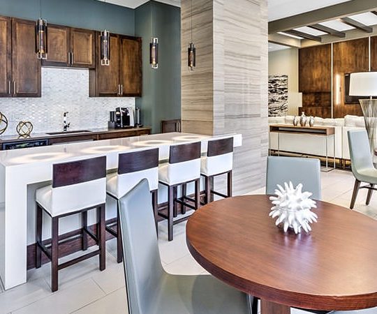 a kitchen and dining area with wood cabinets and stainless steel appliances at The Teak at  Branch
