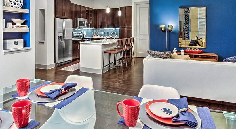 a kitchen and dining area with blue walls and red accents at The Teak at  Branch