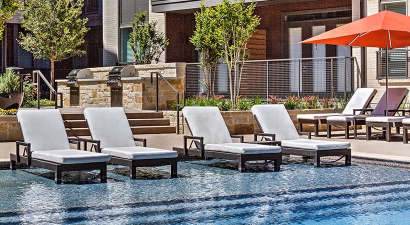 a pool with lounge chairs and umbrellas at The Teak at  Branch